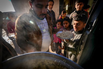 Un grupo de personas recibe alimentos en la ciudad siria de Raqa.