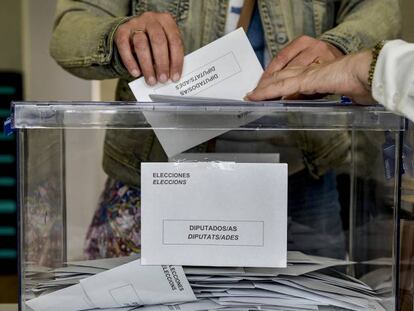 Una persona deposita su voto en una urna electoral, en Cataluña.