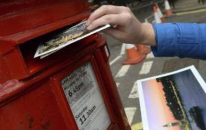 Una persona introduce una carta en un buzón de correos del servicio Royal Mail, en Londres (Reino Unido). EFE/Archivo