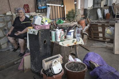 Una vecina de Orihuela (Alicante) espera en la calle junto a sus pertenencias.