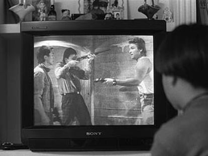Un niño ve una película en el televisor de su casa.