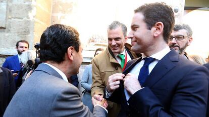 El líder del PP andaluz, Juanma Moreno saluda al secretario general de VOX, Javier Ortega, ante Teodoro García Egea.
