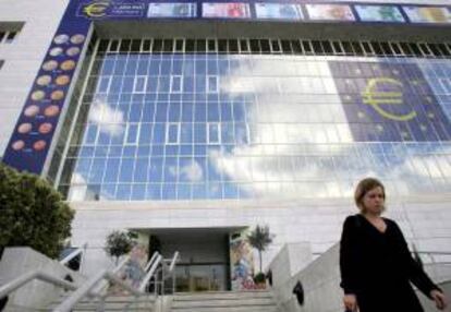 Una mujer chipriota camina delante de un enorme símbolo del euro en la fachada del Banco Central en Nicosia, Chipre. EFE/Archivo