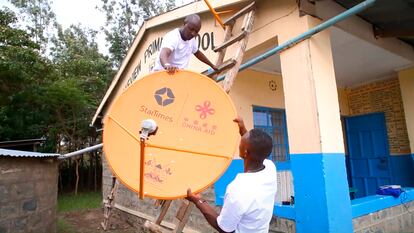 Dos hombres instalan una antena de la empresa china StarTimes en el marco del Proyecto de Acceso a la Televisión Satelital para 10.000 Aldeas en África. Imagen promocional de StarTimes.