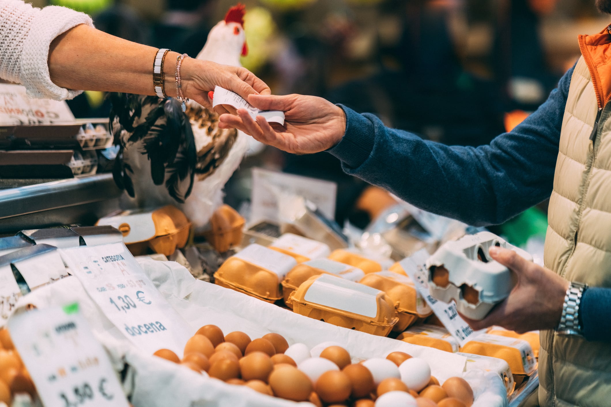 Una mujer recibe un tique y el cambio al comprar huevos en un comercio local.