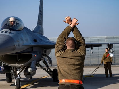 Un aviador estadounidense custodia un F-16 Fighting Falcon asignado al 480º Escuadrón de Caza, en una base aérea cerca de Fetesti, en Rumania, el 17 de febrero de 2022.