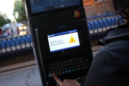 El Ayuntamiento de Madrid prohíbe aparcar en zonas de Servicio de Estacionamiento Regulado (SER) a los no residentes. En la imagen, una persona intenta sacar un ticket de un parquímetro en la calle O'Donnell.