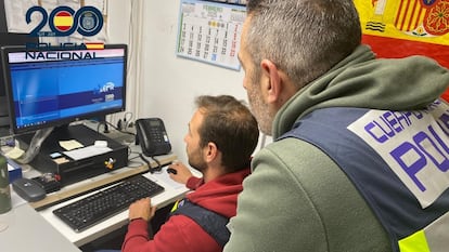Dos agentes de la Policía Nacional trabajan con un ordenador.