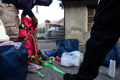 Unos hombres en ruta hacia Europa preparan sus mochilas en el centro de acogida de refugiados antes de reemprender su viaje a través de la frontera alpina francoitaliana.