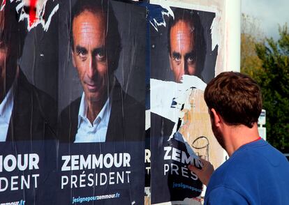 Un hombre arranca carteles de Zemmour, en Biarritz, suroeste de Francia.