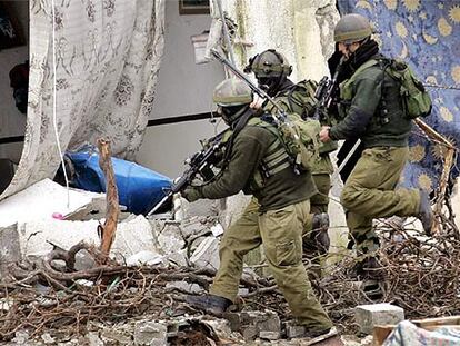 Soldados israelíes entran en una casa palestina después de destruirla ayer en Balata, cerca de Nablus.