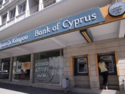 Una cliente saca efectivo en el cajero autom&aacute;tico de una sucursal del Banco de Chipre, en Nicosia.