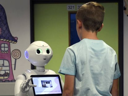 Un ni&ntilde;o habla con el robot Pepper.