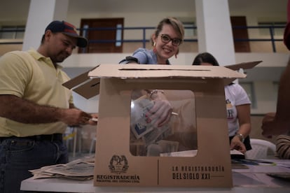 Oficiales electorales extraen los votos de las urnas para empezar el conteo, en Bucaramanga, Colombia, este domingo.