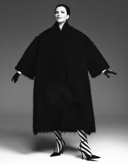 Laura Pausini viste abrigo de Maison Margiela, camisa de Dior, guantes de Guante Varadé, anillo de Grassy, medias de Emilio Cavallini y salones de Saint Laurent X Anthony Vaccarello.