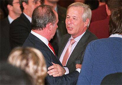 Romero de Tejada (a la derecha) abraza al ministro de Economía, Rodrigo Rato, durante la cena de Navidad del PP en Madrid.