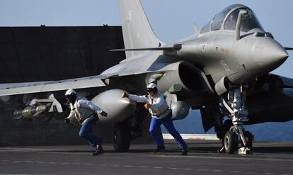 Las operaciones se prolongaron durante siete horas y los aviones de combate franceses fueron repostados en vuelo. En la imagen, soldados de la Marina franceses preparan un avión Rafale.