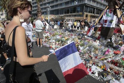 Diverses persones observen aquest dilluns el lloc de l'atemptat a Niça, convertit en punt d'homenatge a les víctimes.