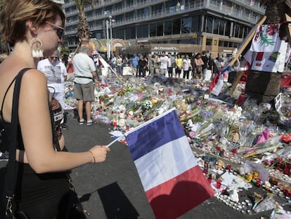 Diverses persones observen aquest dilluns el lloc de l'atemptat a Niça, convertit en punt d'homenatge a les víctimes.