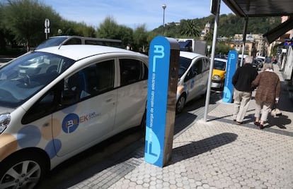 Dos de los coches eléctricos en alquiler situados junto a los postes de recarga en la calle Hernani de San Sebastián.