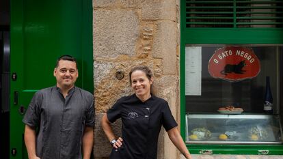 Xoan Costoya con su mujer, Veronica Moure, que también trabaja en la taberna, posan en el exterior de la tasca O Gato Negro.