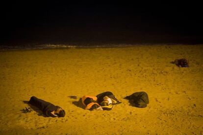 Un grupo de turistas duerme en la playa de la Barceloneta.