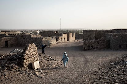 Una mujer camina entre las destartaladas casas de Tichit. El asentamiento comercial medieval de esta ciudad es ahora Patrimonio de la Humanidad por la UNESCO desde 1996 junto con otras capitales parecidas de la región llamadas Ouadane, Chinguetti y Oualata. En Tichit apenas se ven vehículos. "Puede pasar un mes sin que venga ninguno", dice Chérif Mokhtar Mbaka, profesor de inglés en el instituto comunal.