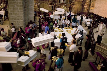 Algunas personas comienzan a llevar los ataúdes de sus seres queridos en el funeral en Chungui (Perú).