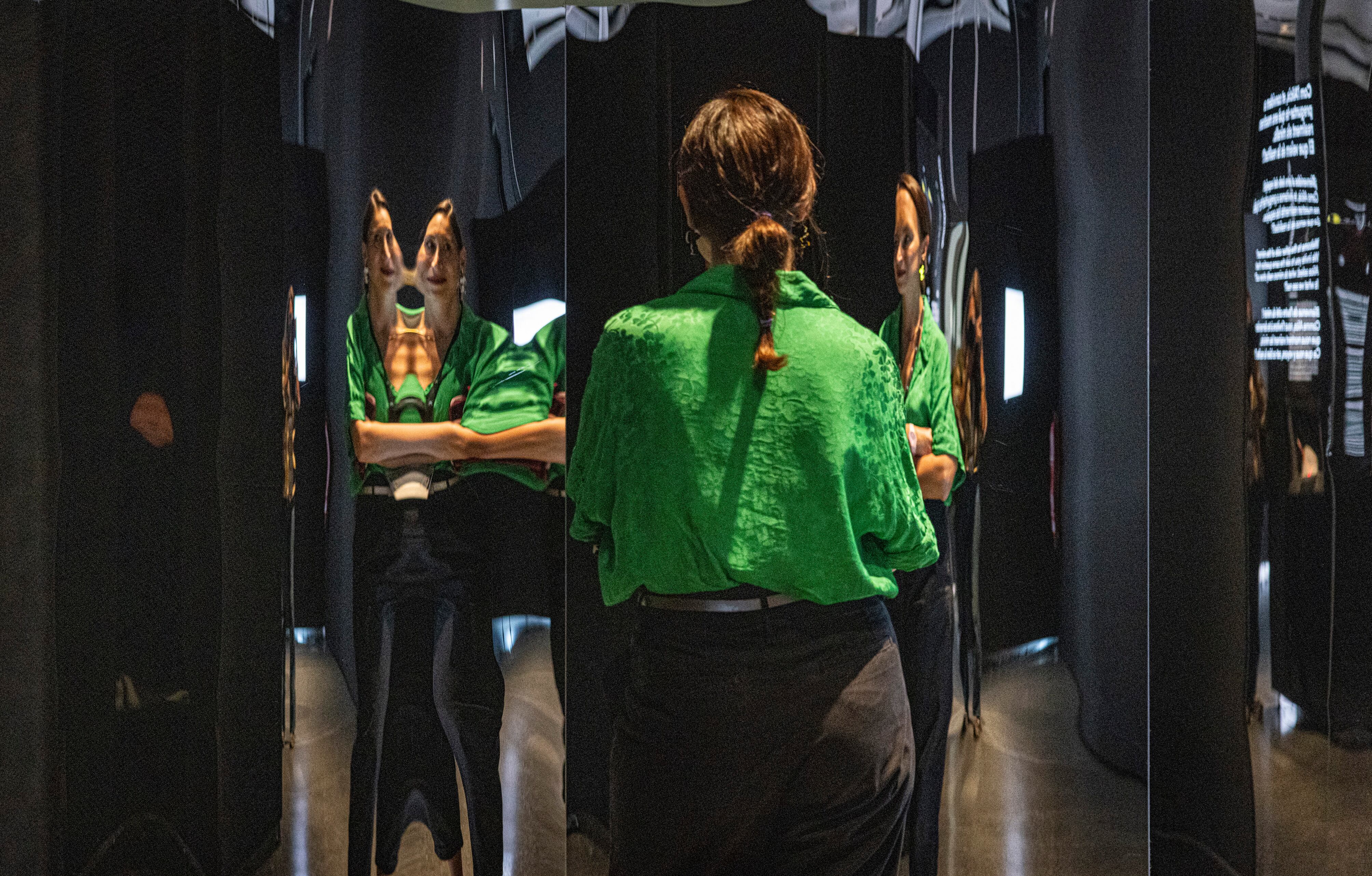 Una mujer mira su imagen deformada en espejos cóncavos y convexos de la exposición 'Espejos. Dentro y fuera de la realidad' en e CaixaForum Valencia.