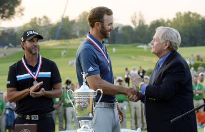 Dustin Johnson, en el centro, recibe la felicitaci&oacute;n de Jack Nicklaus.