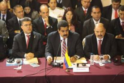 Fotografía cedida por la Presidencia de Venezuela el 12 de julio de 2013, que muestra al mandatario venezolano, Nicolás Maduro (c), acompañado del canciller Elías Jaua (i), durante la Cumbre de Mercosur en Montevideo (Uruguay).