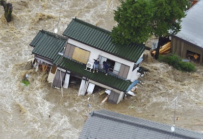 Unos vecinos de Joso (Japón), esperan a ser rescatados por un helicóptero en el tejado de su casa, mientras ésta flota por las aguas del río que se ha desbordado por las fuertes lluvias.