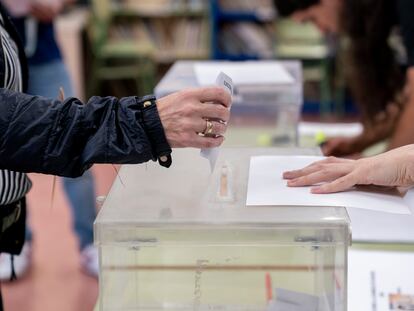 Una persona deposita su voto en la urna en un colegio electoral, el 28 de mayo de 2023, en Madrid.