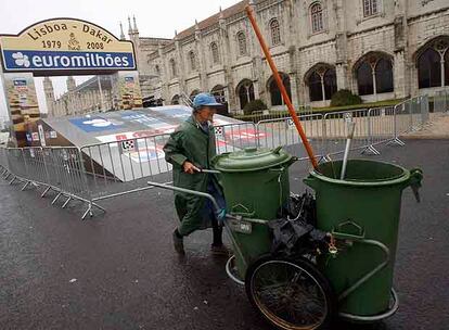 Una trabajadora de la limpieza de Lisboa, ayer ante la desierta rampa de salida del Rally Dakar.