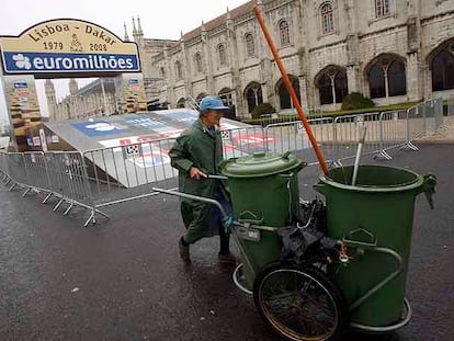 Una trabajadora de la limpieza de Lisboa, ayer ante la desierta rampa de salida del Rally Dakar.