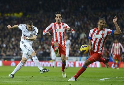 Benzema prueba el remate, que da en la mano del Cata.