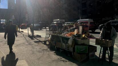 Un hombre pasa frente a un puesto de frutas callejero en el barrio de Manhattan, en Nueva York.