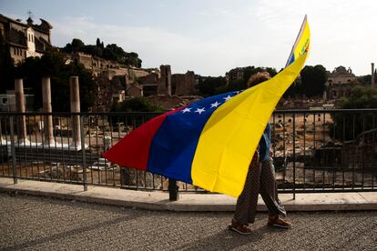 Un hombre camina con una bandera venezolana por las calles de Roma, (Italia)