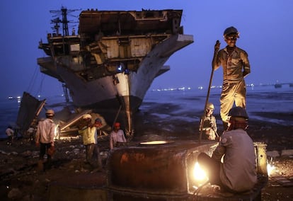 Un grupo de trabajadores realiza labores de desguace de barcos en Bombay, India.