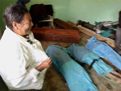 Una mujer llora frente a los cadáveres de tres miembros de su familia en Tecpan, al oeste de la ciudad de Guatemala.