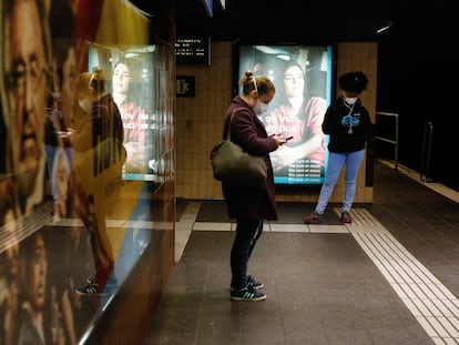 Dos mujeres miran el móvil en el metro de Barcelona.