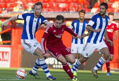 Pawlett se lleva el balón frente a dos jugadores de la Real