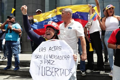 Una mujer sostiene un cartel este martes, durante una protesta contra los resultados dados por el CNE, en Caracas.