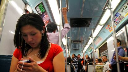 Una joven utiliza su teléfono inteligente mientras viaja en el metro de Ciudad de México.