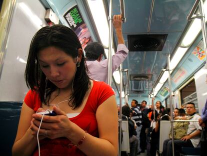 Una joven utiliza su teléfono inteligente mientras viaja en el metro de Ciudad de México.