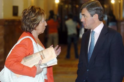 Celia Villalobos, ex ministra del PP, habla con el secretario general de su partido, Ángel Acebes, antes de la votación.