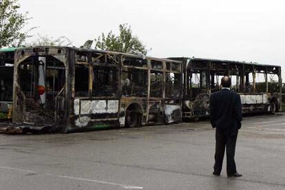 Un conductor de autobuses observa los restos del vehículo quemado anoche en Grigny.