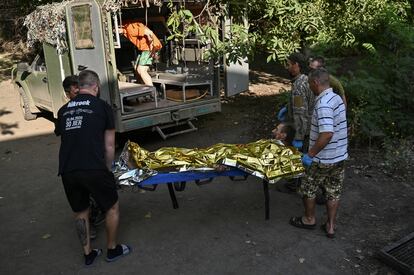 Medics carry an injured Ukrainian serviceman to an ambulance vehicle outside a frontline medical stabilisation point, amid Russia's attack on Ukraine, in Ukraine July 27, 2023.