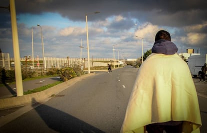 Joven iraní de 19 años espera en la carretera al lado de la conocida como "La Jungla", en Calais (Francia), a que un camión pare para poder desplazarse a Reino Unido.