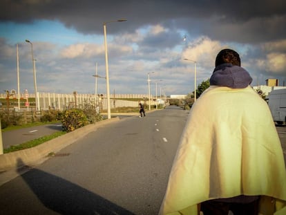 Joven iraní de 19 años espera en la carretera al lado de la conocida como "La Jungla", en Calais (Francia), a que un camión pare para poder desplazarse a Reino Unido.